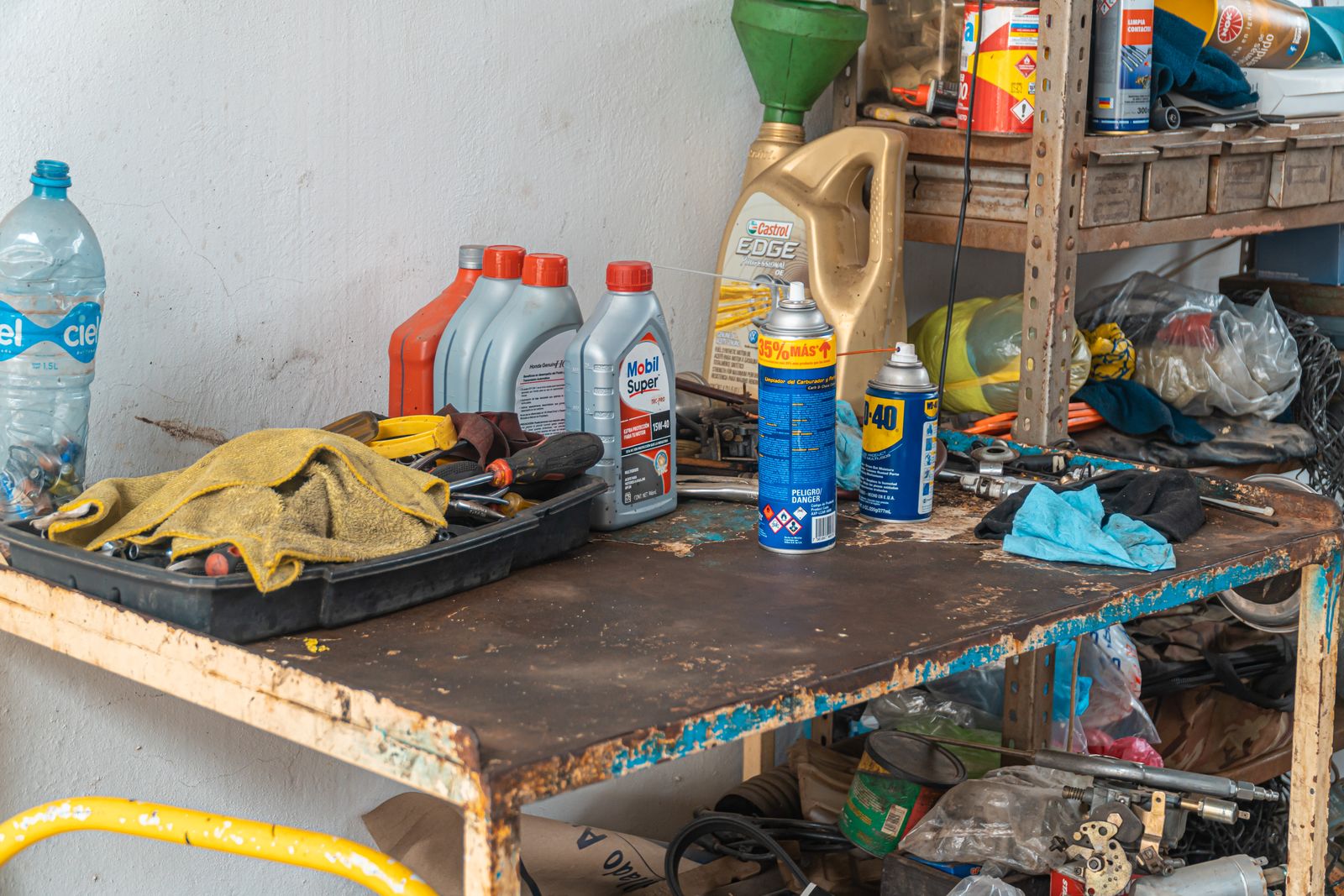 Paint tins, solvents and a propane cylinder on a garage shelf